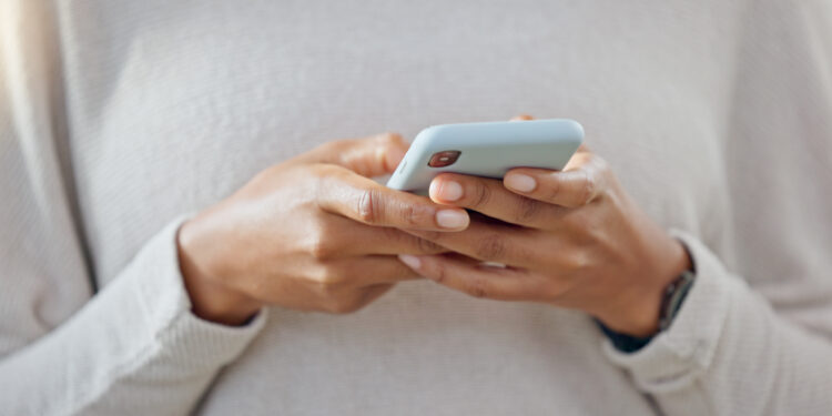 Person, phone and hands typing in social media, communication or online networking at home. Closeup of freelancer texting, chatting or research on mobile smartphone app for email or message in house
